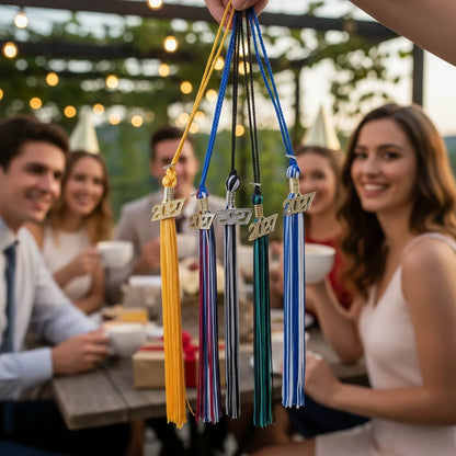 Rocky Mountain Balfour 2027 graduation souvenir tassels in various school colors held against a blurred party backdrop